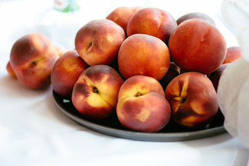Fototapeta na wymiar Summer tasty peaches on plate with white background