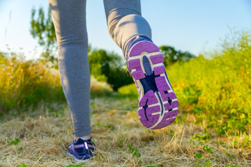 Woman running at sunset in a field