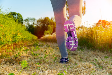 Woman running at sunset in a field