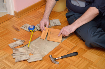 Worker Repairing Damaged Parquet