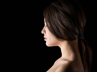 Portrait of a beautiful young brunette. Beauty on a black background.