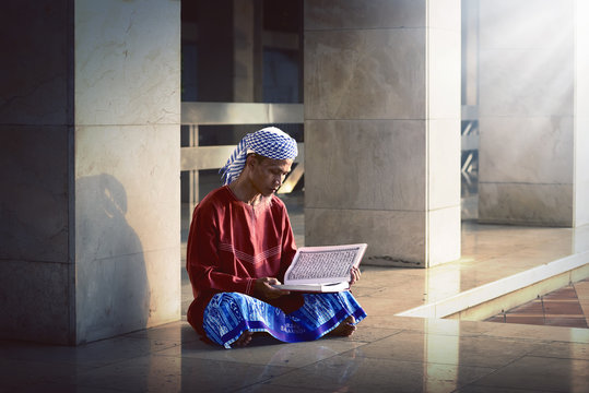 Religious muslim man reading holy koran