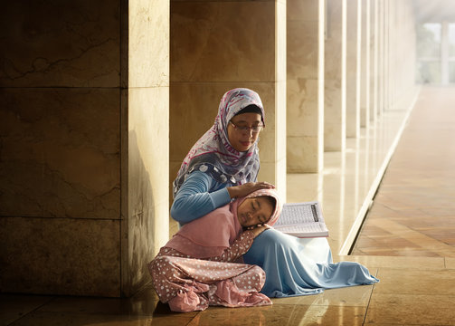 Muslim mother teach her daughter reading koran