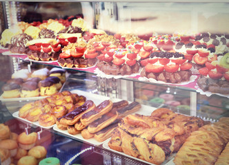 Sweet waffles with cream and fresh fruits. Sweet food behind the window of a bakery. Delicious waffles with decorative fresh cream topping and fruits.