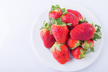 Strawberry red on a white plate and a white background, a bright image with contrast. side view, top. summer red berries. a series of color photographs