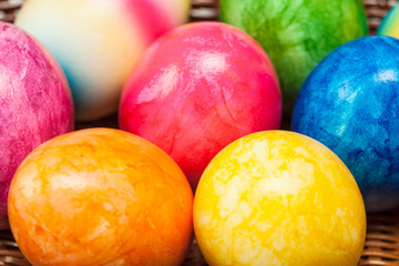 Fototapeta na wymiar Bunch of colorful easter eggs in small basket