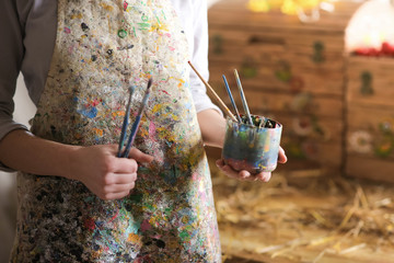 Closeup of female artist hand holding paintbrush
- 103906483