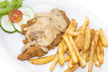Schnitzel with mushroom sauce and french fries on a white background in the restaurant
