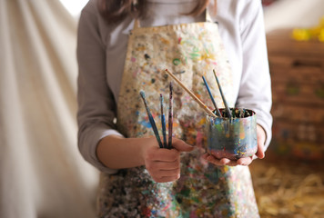 Closeup of female artist hand holding paintbrush
- 103906601