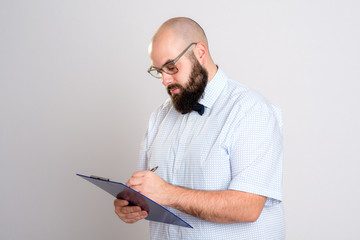 bearded man with clipboard in front of gray background