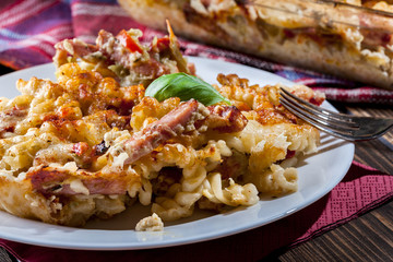 Portion of fusilli pasta casseroles, sausages and zucchini