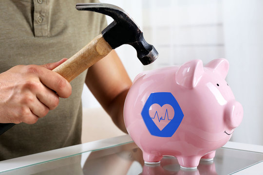 Man with a hammer going to break the piggy bank, close up