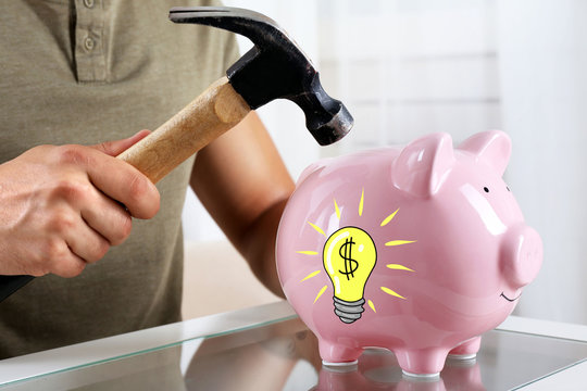 Man with a hammer going to break the piggy bank, close up