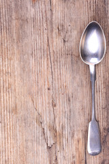 background wood surface and old vintage silver spoon top view