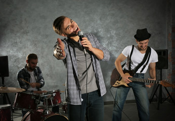 Musicians playing musical instruments and singing songs in a studio