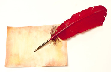 Sheet of aged golden colored paper with red quill pen