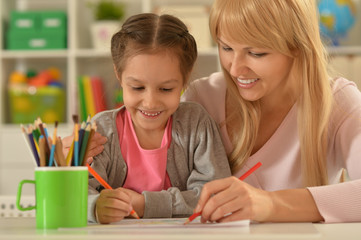 Girl painting with mother