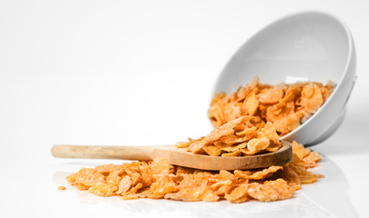 Oat flakes in bowl and wooden spoon on white background