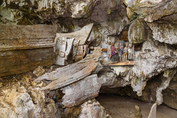 Wooden statues of Tau Tau and coffins in TampangAllo burial cave at Tana Toraja. Indonesia