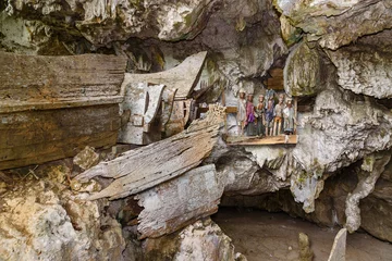 Foto op Canvas Wooden statues of Tau Tau and coffins in TampangAllo burial cave at Tana Toraja. Indonesia © Elena Odareeva