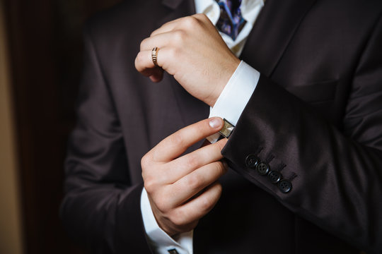 Mans hands with cufflinks. Elegant gentleman brown clother