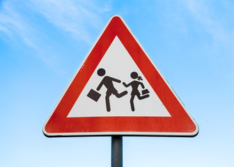 Road sign caution children over blue sky