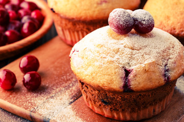 Cranberry muffins on wooden background.