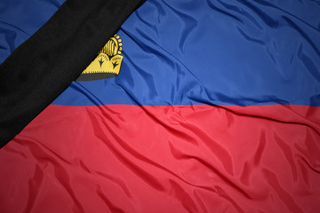 national flag of liechtenstein with black mourning ribbon