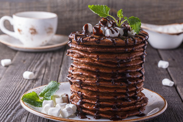 Stack of pancakes with marshmallow and chocolate syrup.