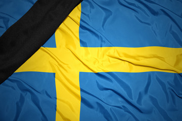 national flag of sweden with black mourning ribbon