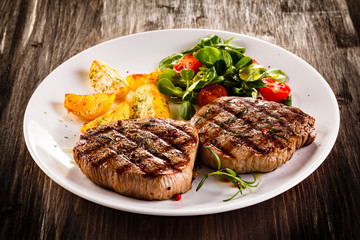 Grilled beefsteaks and vegetables