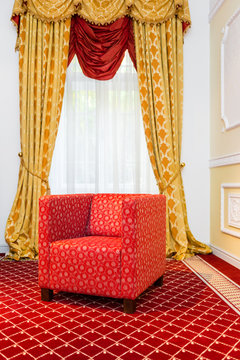 Empty Red Chair In The Room With Vintage Red Carpet And Classic Yellow Drapes