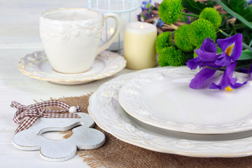 porcelain on cloth near green chrysanthemum with other flowers on wooden white table