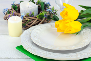 porcelain on the tissue near the yellow tulips on white wooden table