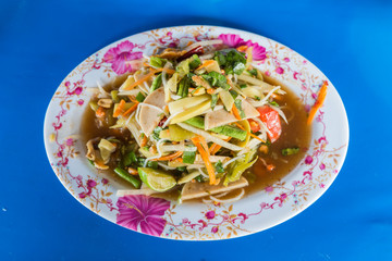 green papaya spicy salad Thai style on blue background