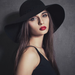 Fashion portrait of beautiful sexy young female in hat with red