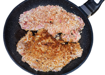 top view of two schnitzels are fried in pan