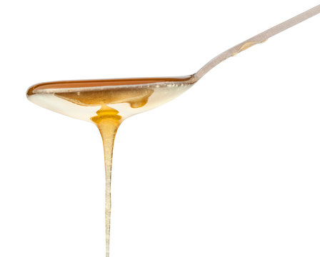 Clear Honey Flowing Down From Teaspoon Close Up