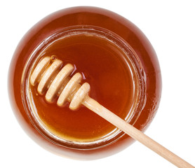 above view of wooden spoon on glass jar with honey