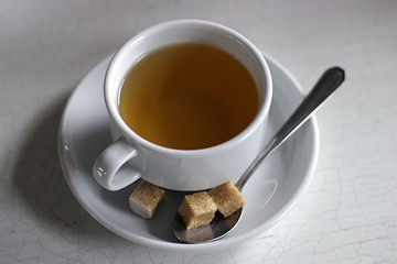 tea cup with brown sugar on a plate