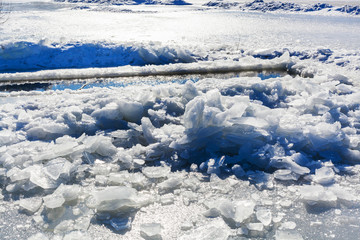 broken ice near hole in frozen lake