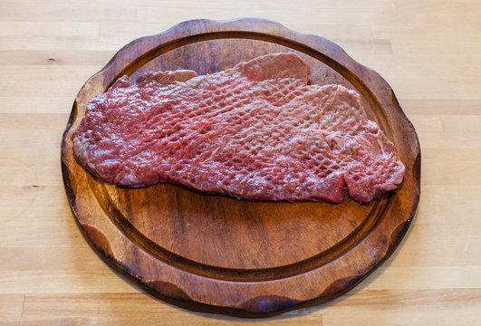 beaten slice of veal on cutting board