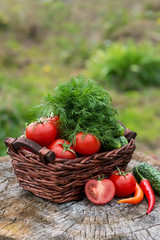 Basket and wooden plate with fresh vegetables