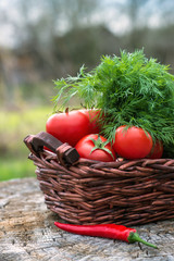 Basket and wooden plate with fresh vegetables