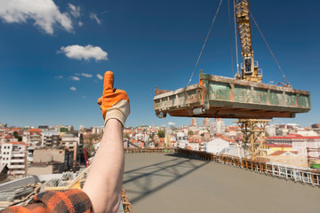 Construction worker signaling to crane operator