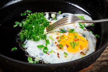 fried egg with greens in pan