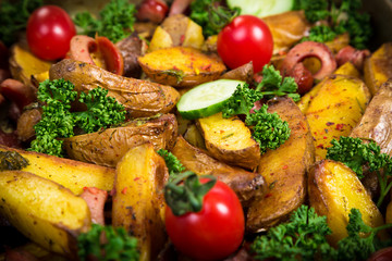 baked sliced potatoes with sausages, Food background