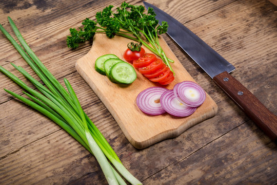 cutting board with greens and vegetables