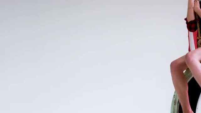 Medium shot of young Caucasian girl with waving American flag riding on a tire swing against white background. 1080 HD 120 FPS Slow motion. Shot with Blackmagic URSA Mini