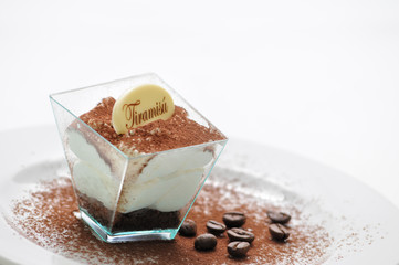 tiramisu in taster with cocoa powder and coffee beans on white plate, italian desserts, patisserie,...
